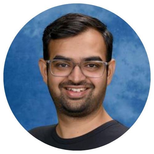 Headshot of a smiling person with glasses against a blue background