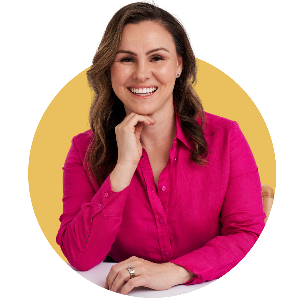 Smiling woman in a bright pink shirt posed against a yellow circular background