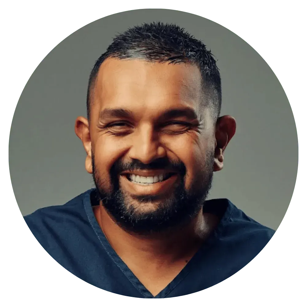 Smiling man in a dark blue shirt against a gray background