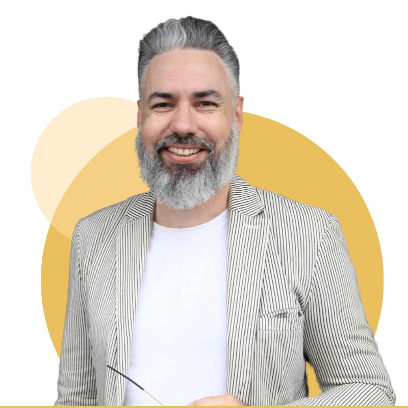 Smiling man with gray beard in a striped blazer over a white shirt, against a yellow abstract background