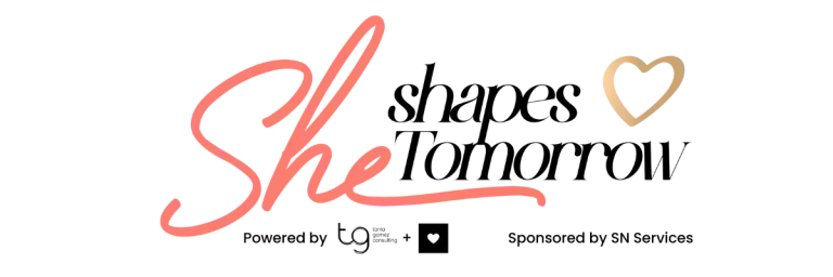 Logo reading “She shapes tomorrow” in pink, black, and gold with a heart icon and sponsor text below