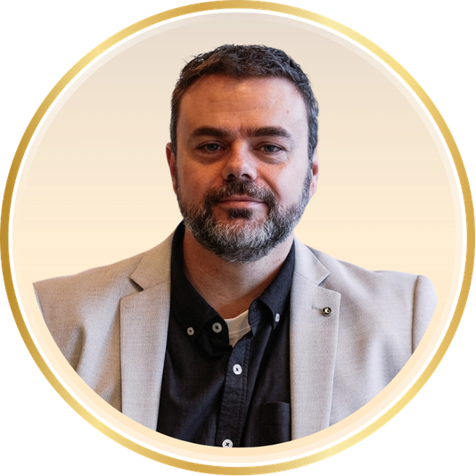 Portrait of a man in a light blazer and dark shirt inside a gold-rimmed circle