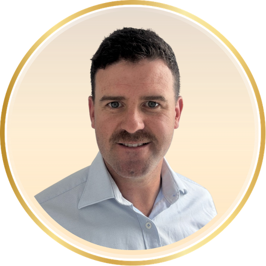 Portrait of a man in a light blue shirt inside a gold circular frame on a cream background