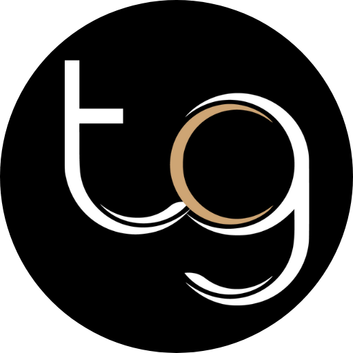 Stylized white and tan “tg” letters on a black circular background