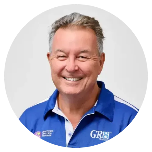 Smiling man in blue GR8 polo shirt against a light gray background