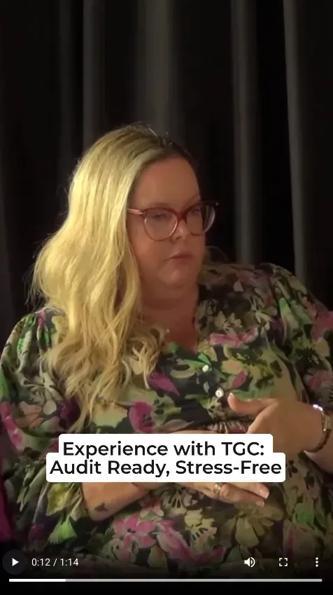 Woman speaking onstage with microphone, wearing glasses and floral top, with caption about TCC audit readiness.