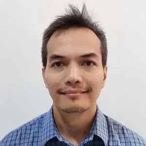 Portrait of a smiling man in a blue checkered shirt against a plain white background
