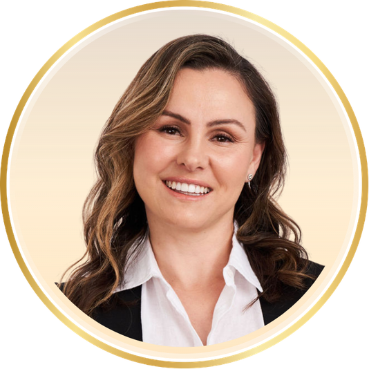 Portrait of a smiling woman in a white shirt and dark blazer, framed by a gold circular border.