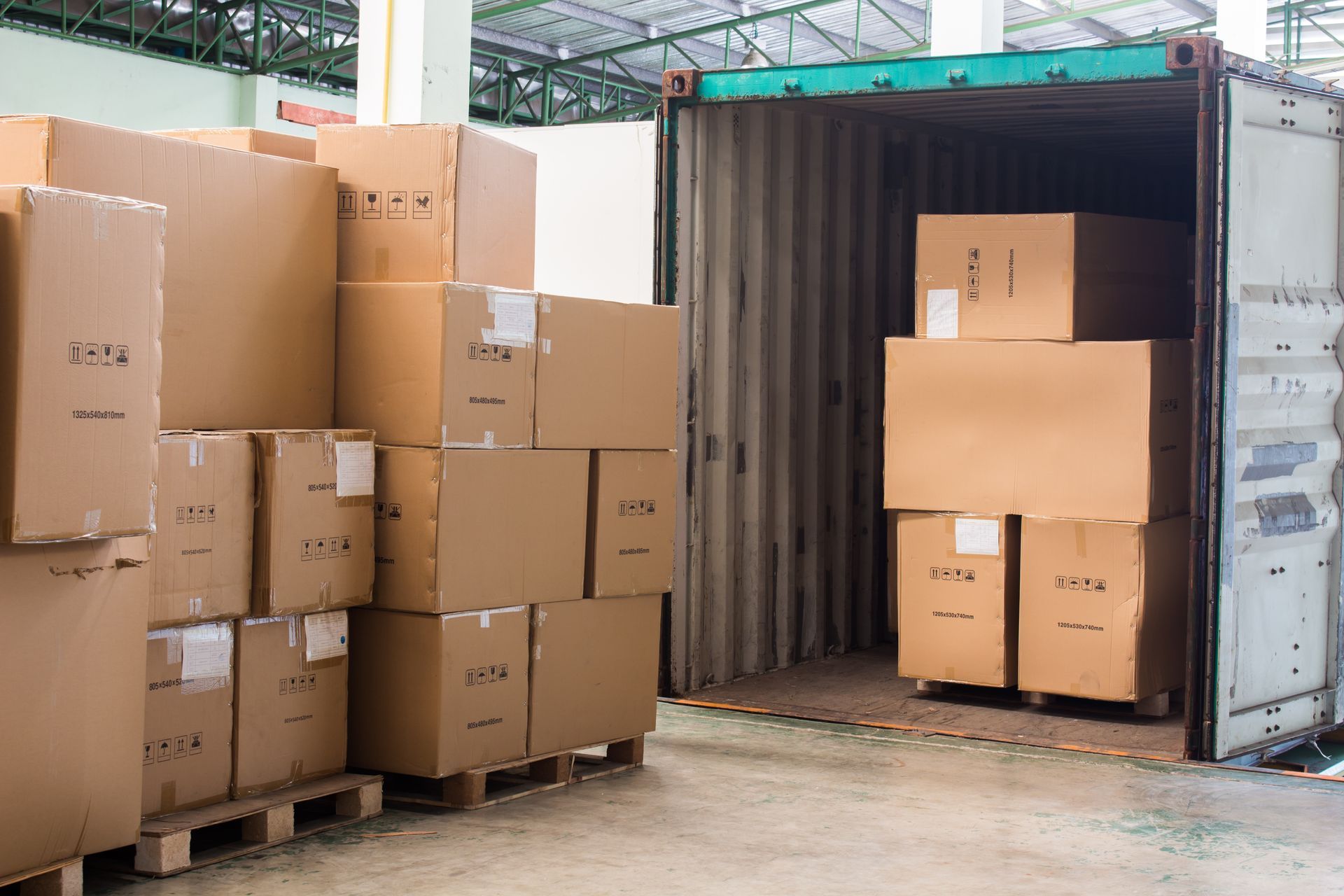 A warehouse filled with lots of cardboard boxes and pallets.