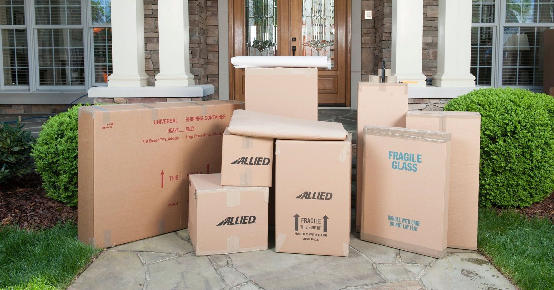 Des cartons empilés sur le perron, prêts à être chargés pour un déménagement.