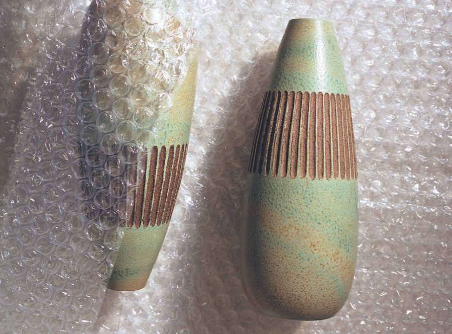 Two ceramic vases are wrapped in plastic bubble wrap