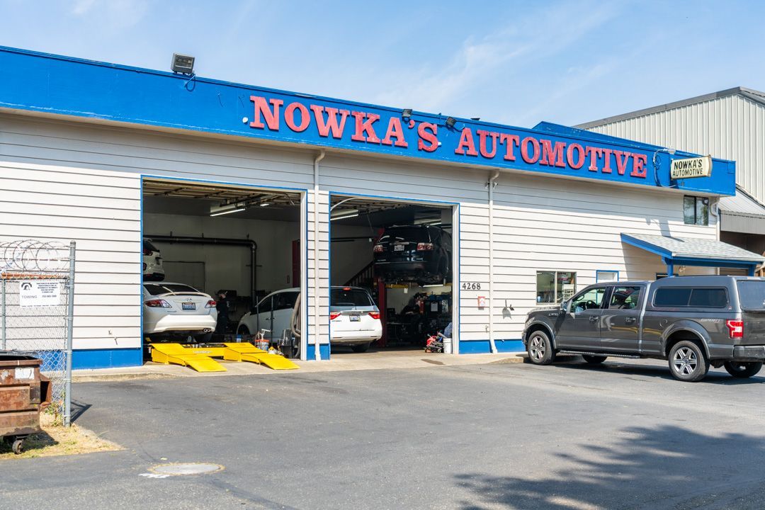 Nowka’s Automotive garage with open bays and parked SUV under a blue roof