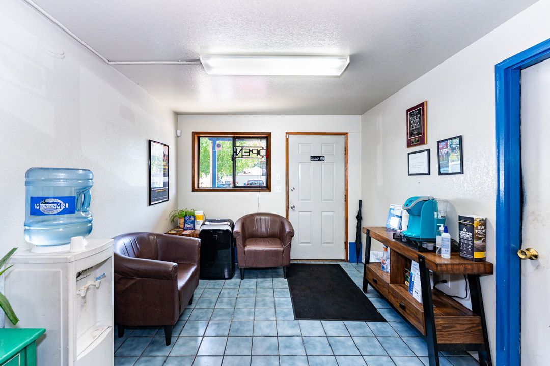 Waiting room with brown chairs, water cooler, blue door frame, and wall art