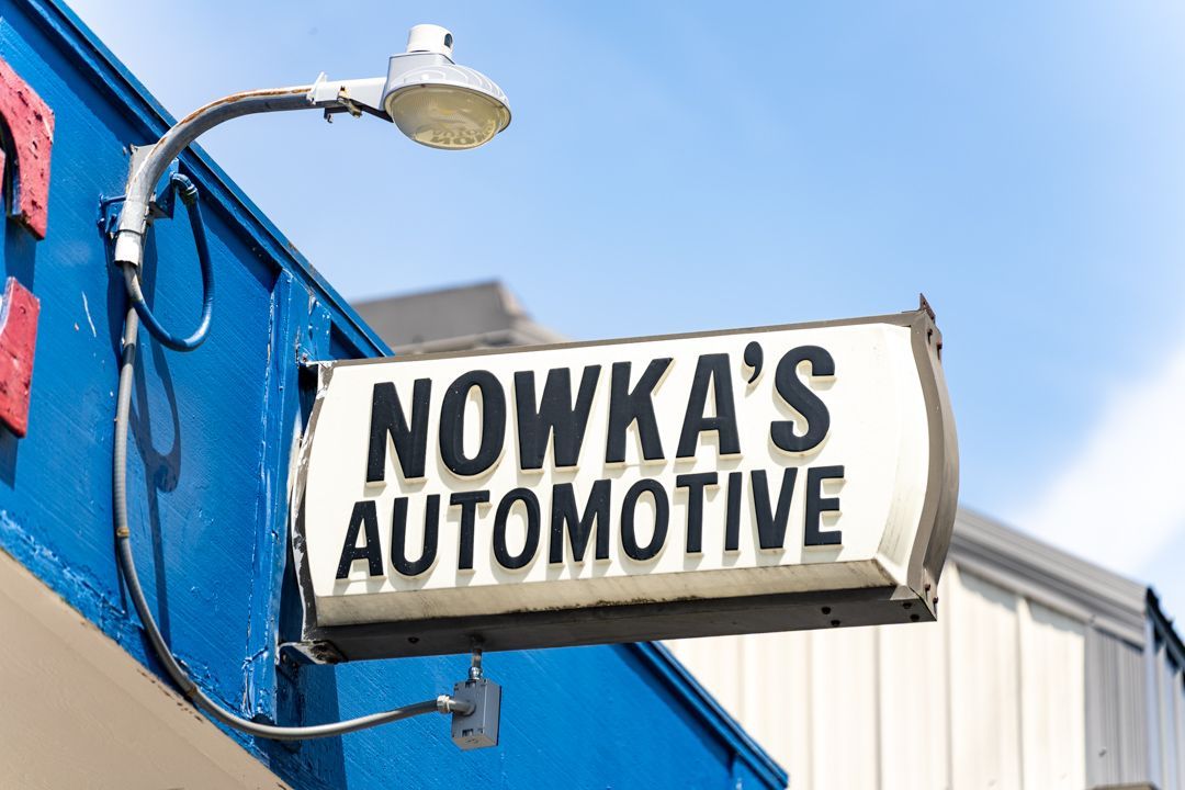Nowka’s Automotive sign on a blue building against a clear sky