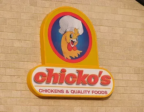 Chicko 's chickens and quality foods sign on a brick wall
