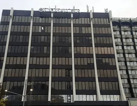 A large building with a lot of windows and a sign on top
