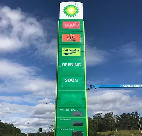 A large green bp sign that says opening soon