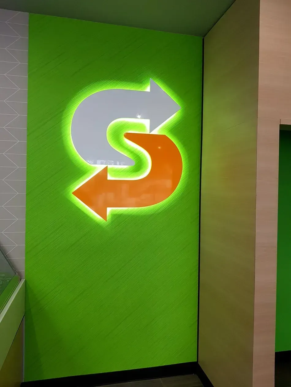 A green wall with a subway logo on it