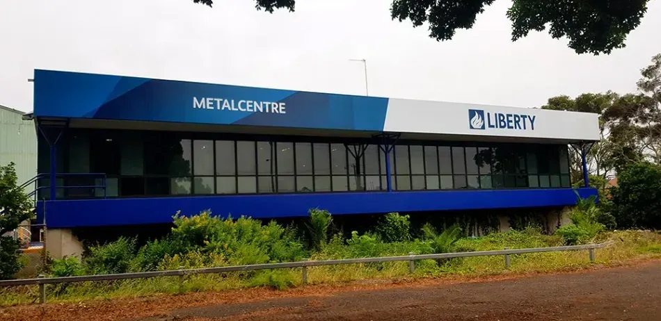 A large blue and white building with a fence in front of it.