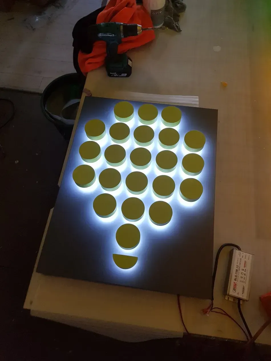 A bunch of circles on a table with a drill in the background