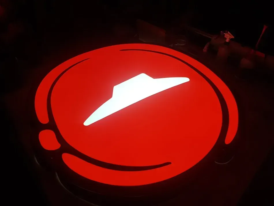 A pizza hut logo is lit up in the dark