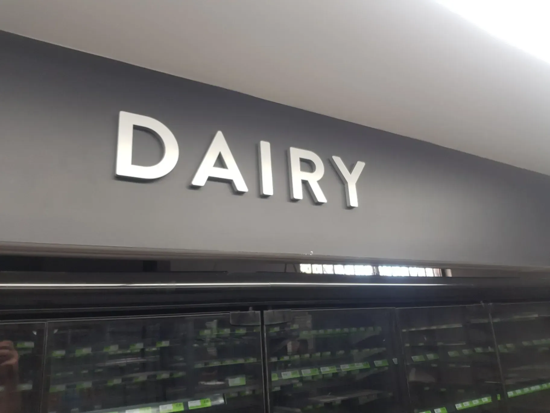A dairy section of a store with a sign above it
