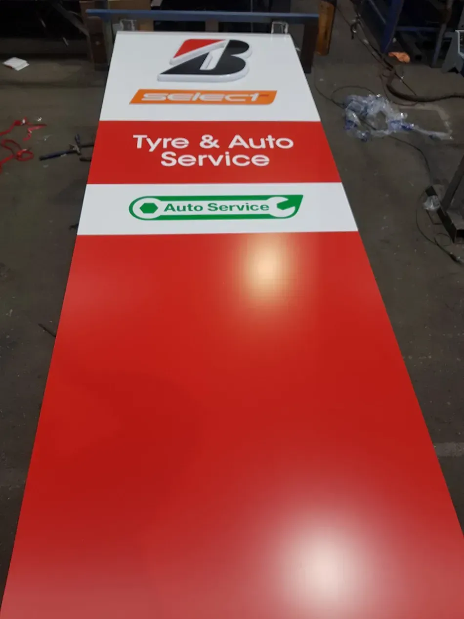 A red and white sign for a tire and auto service