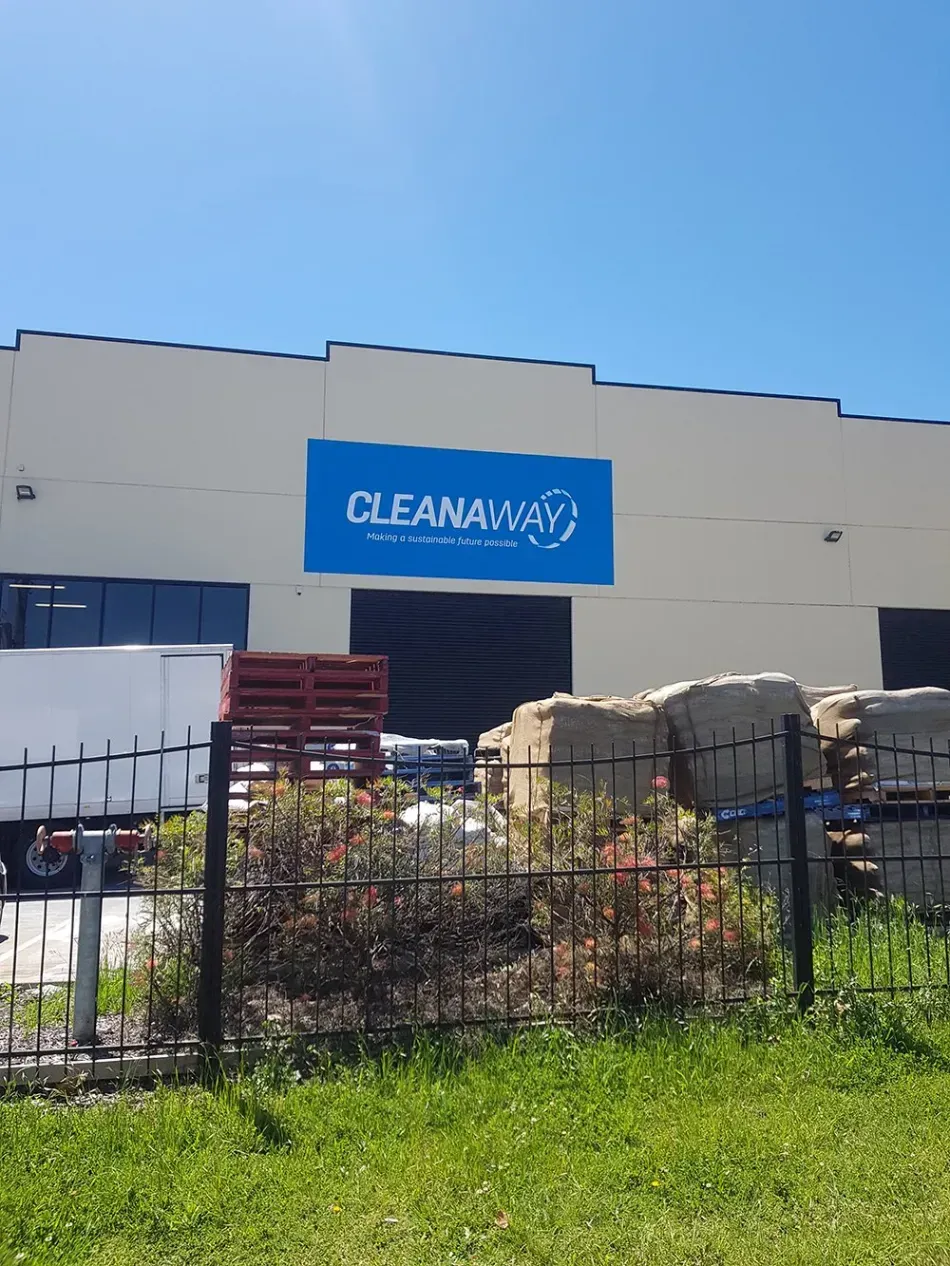A white building with a blue sign that says cleanaway