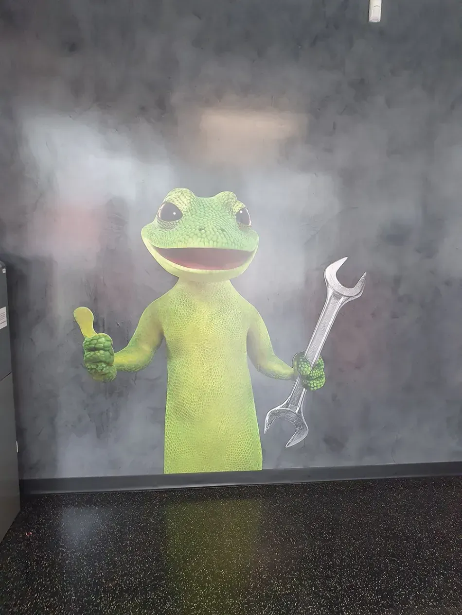 A frog is holding a wrench and giving a thumbs up.