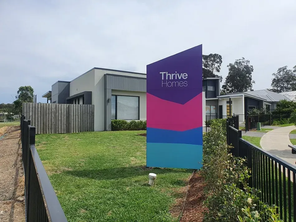 A sign in front of a house that says thrive homes