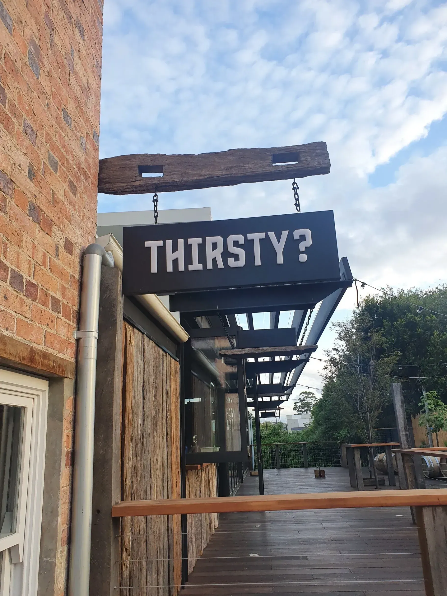 A sign on the side of a building that says thirsty