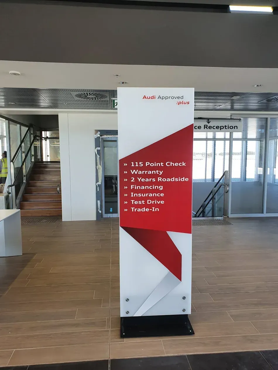 A red and white sign with the word audi on it