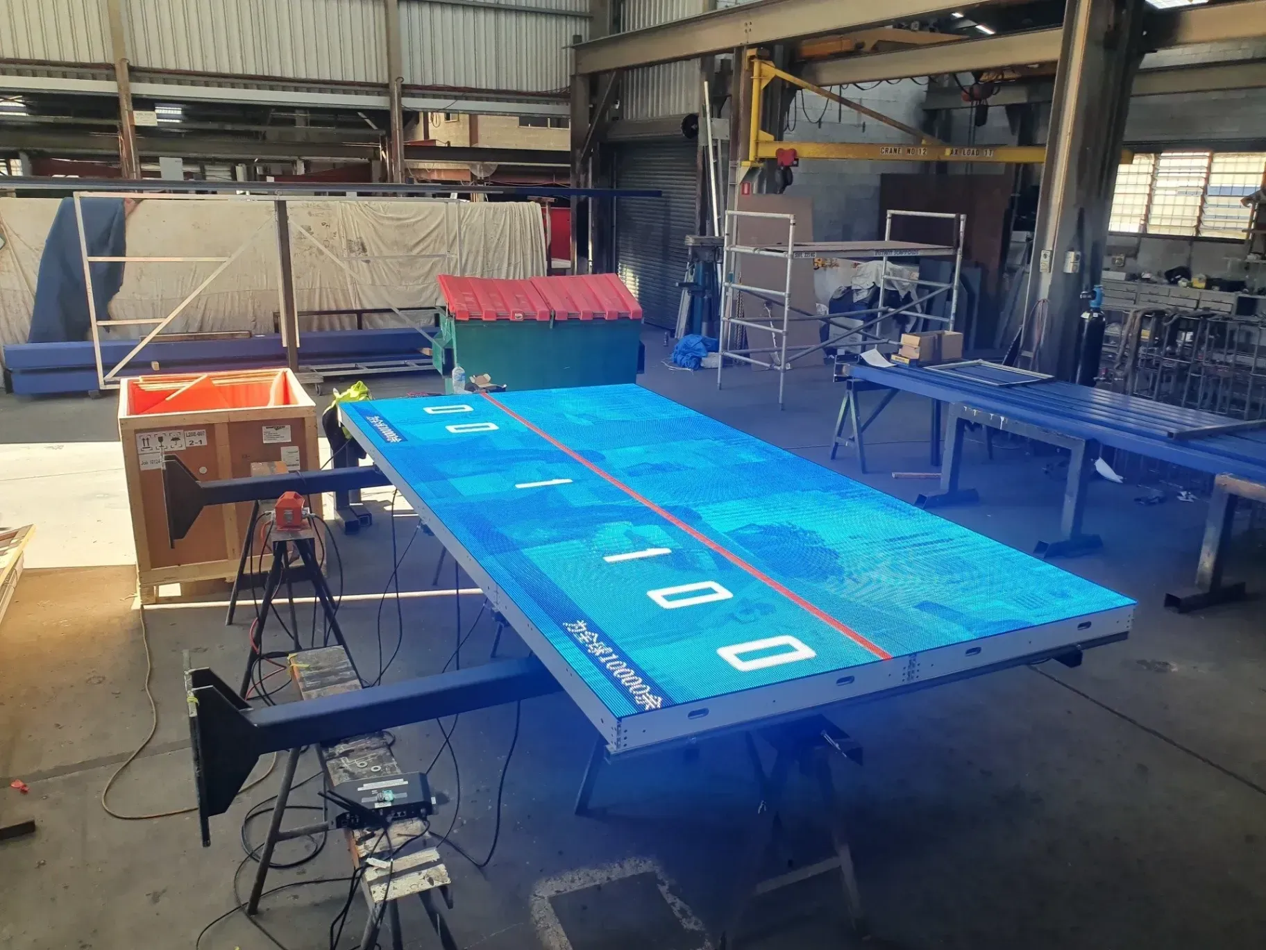 A large blue table is sitting in a warehouse.