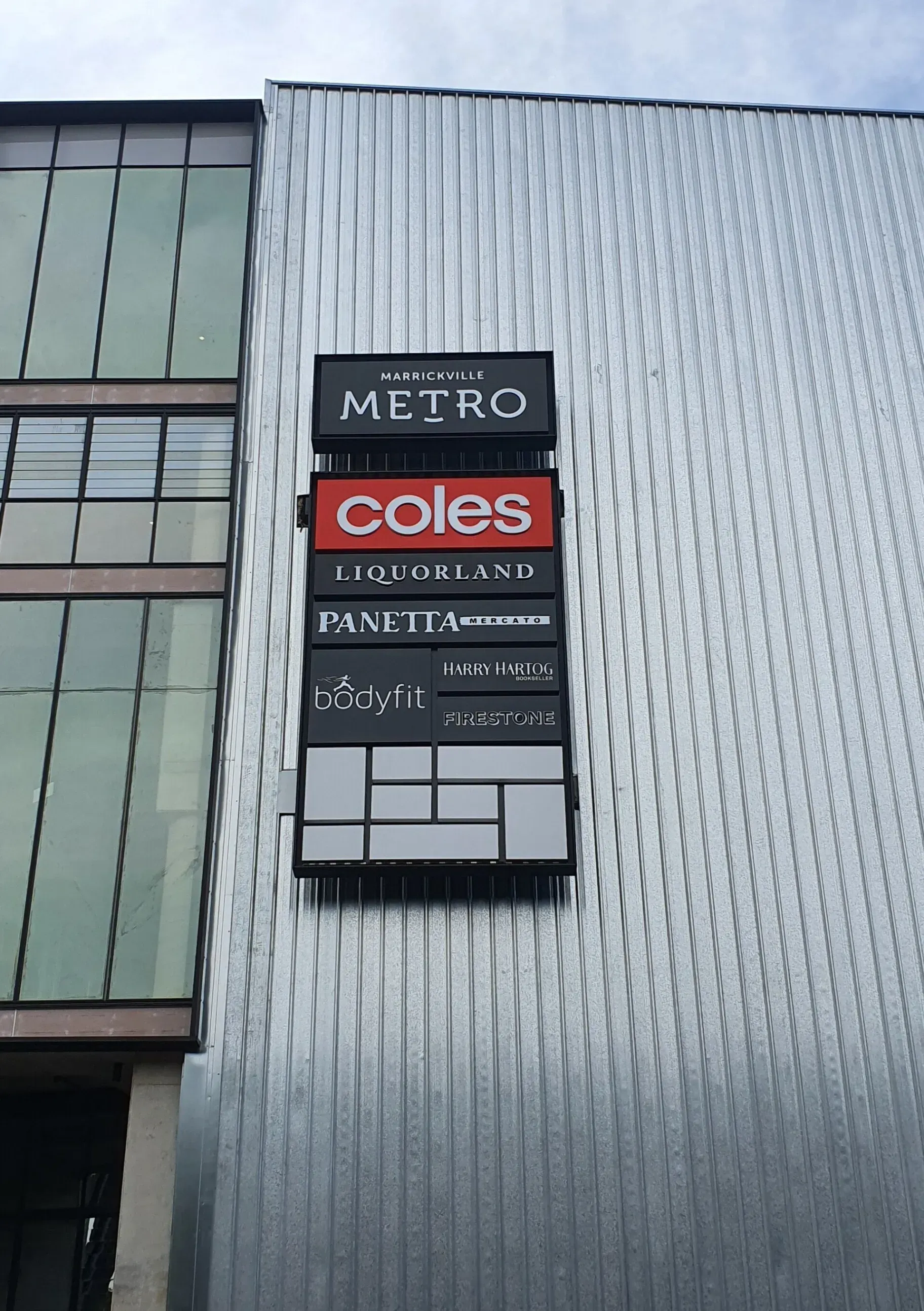 A sign on the side of a building that says coles