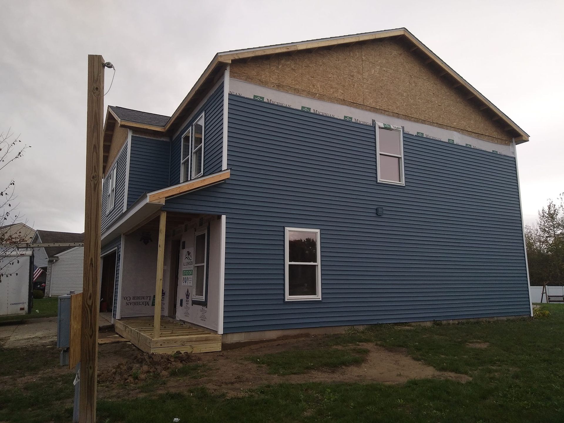 A blue house with a porch is being built