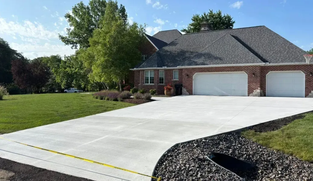 Newly poured concrete pavement sections with visible seams and a wooden border.