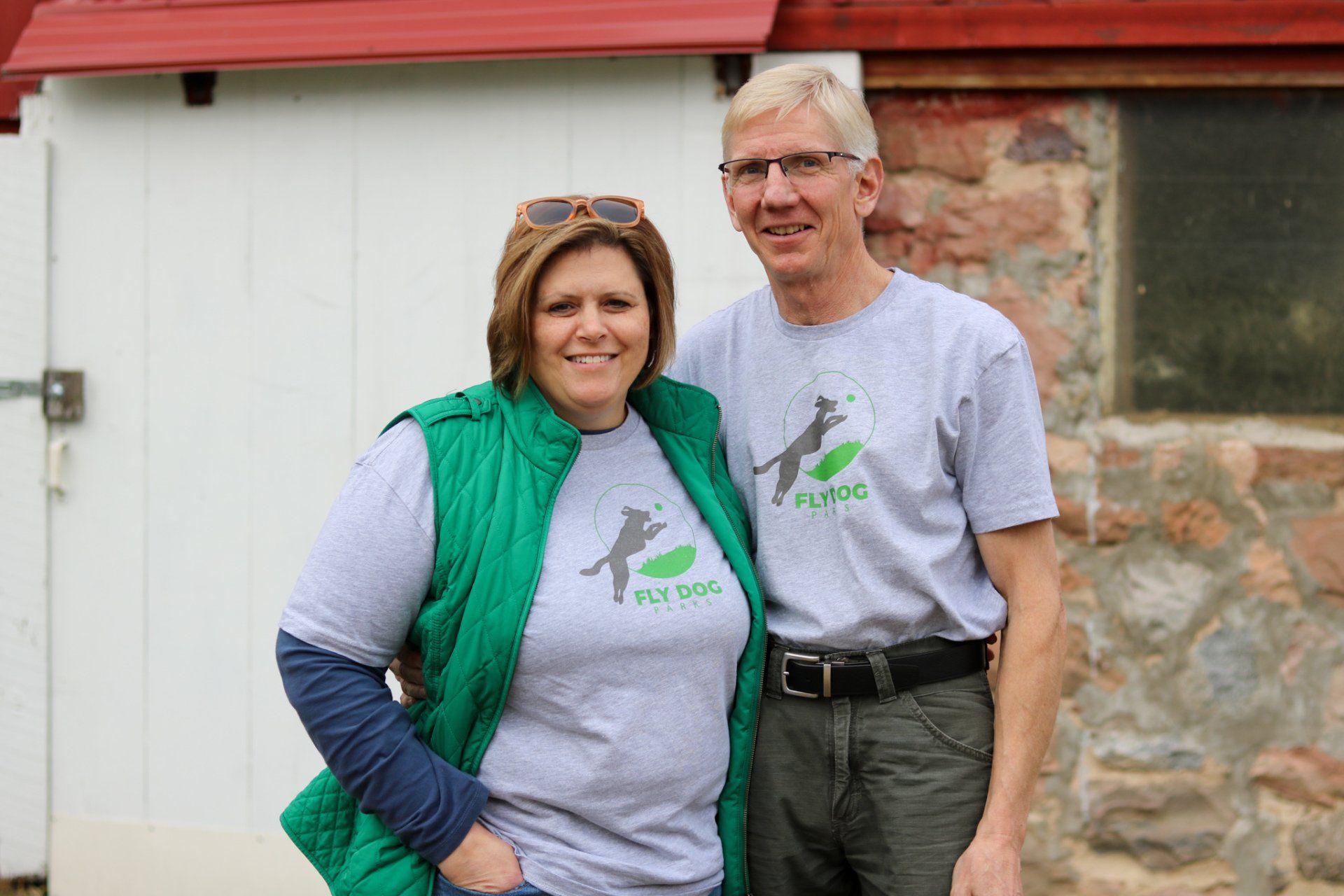 A man and a woman are posing for a picture in front of a building.