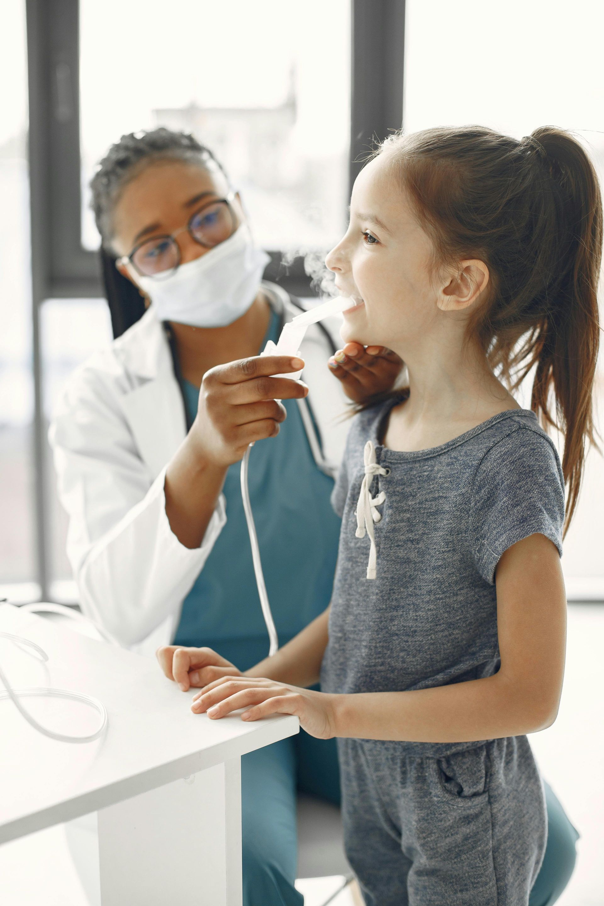 A doctor is examining a little girl 's chest with a stethoscope.