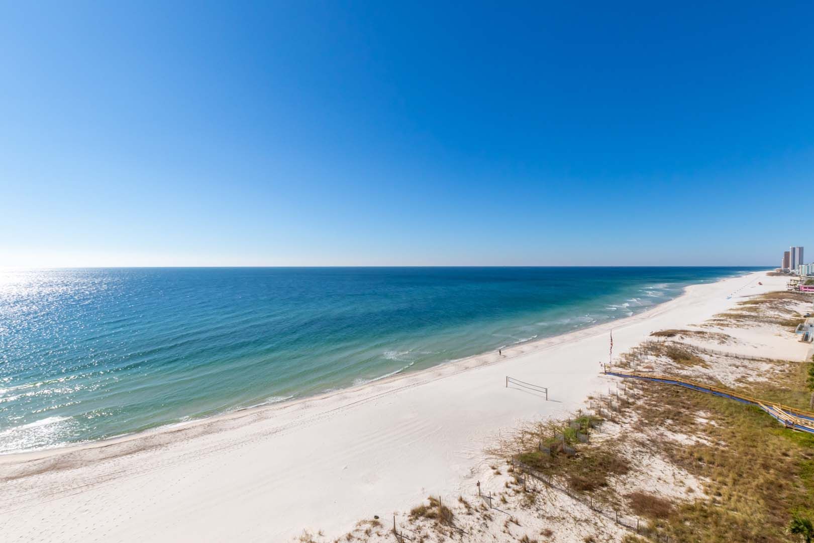 An aerial view of a beach and ocean on a sunny day.