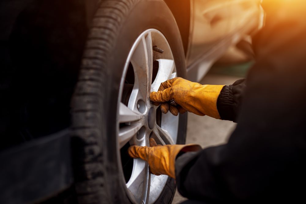 A Person Is Changing A Tire On A Car — C J Mechanical In Berry, NSW