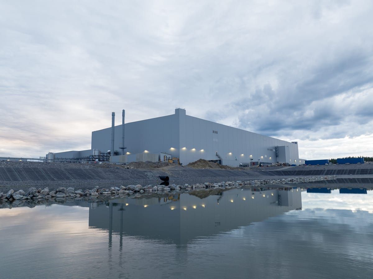 A large white building is sitting next to a body of water.