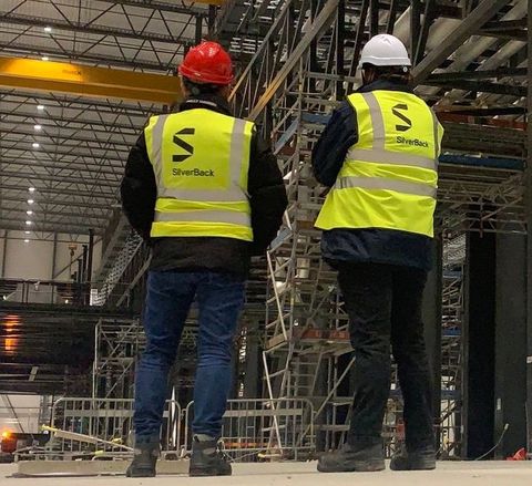 Two men wearing yellow vests with the letter s on them