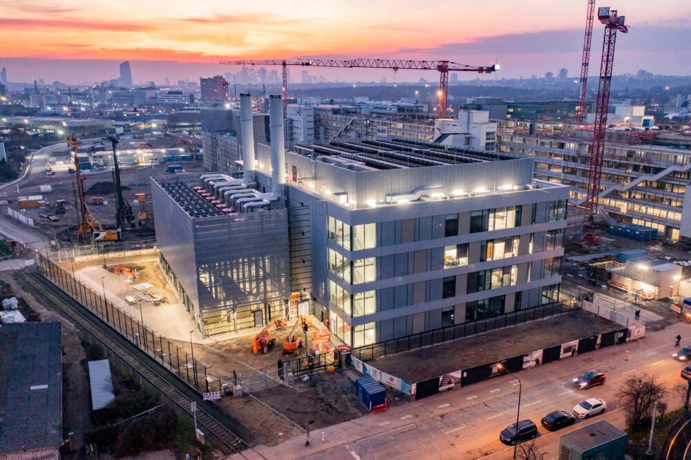 An aerial view of a building under construction in a city at night.
