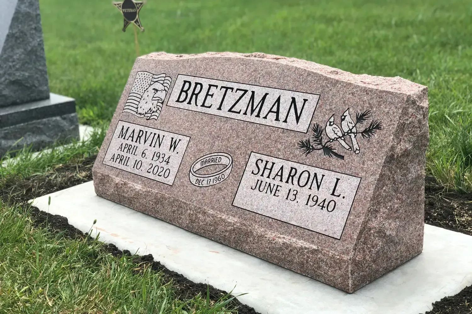 Gravestone for the Bretzman family with engraved names on a pink granite memorial plaque.