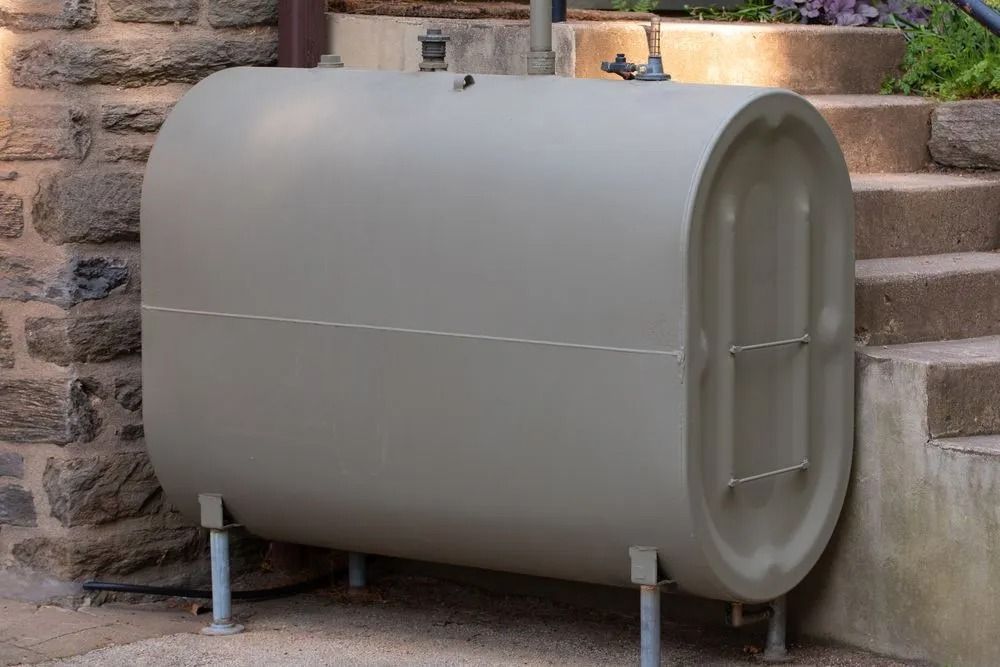 Tan Oil Tank on Metal Legs Beside Stone Steps and Wall — Climate King In Orange, NSW