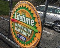 A NAPA AutoCare round yellow and green sign advertising a 