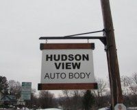 A hanging sign on a wooden utility pole reads 