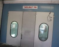 A set of three white industrial doors with oval windows, labeled 