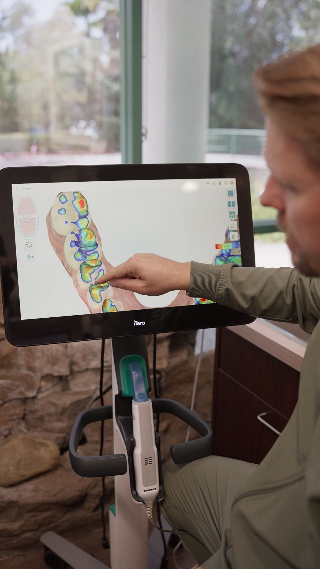 Person using a touchscreen exercise bike with a colorful map displayed on the monitor