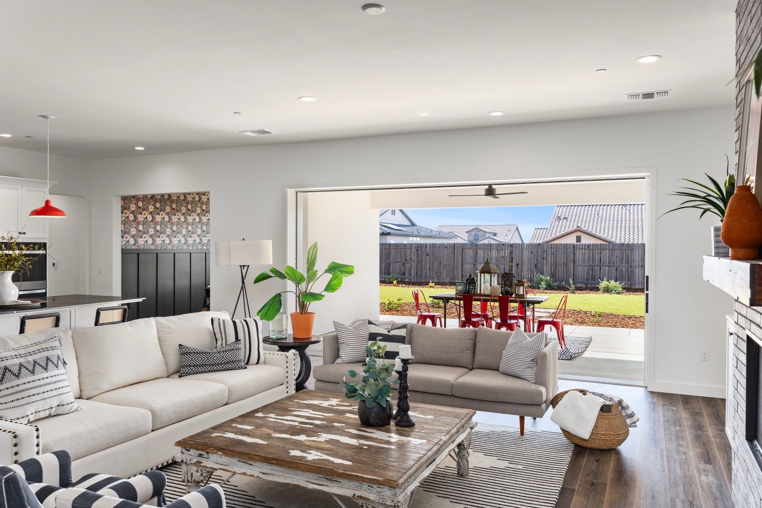 Open-concept living room with a view of the backyard, furnished with white and gray furniture.